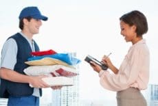 Businesswoman signing for package in office