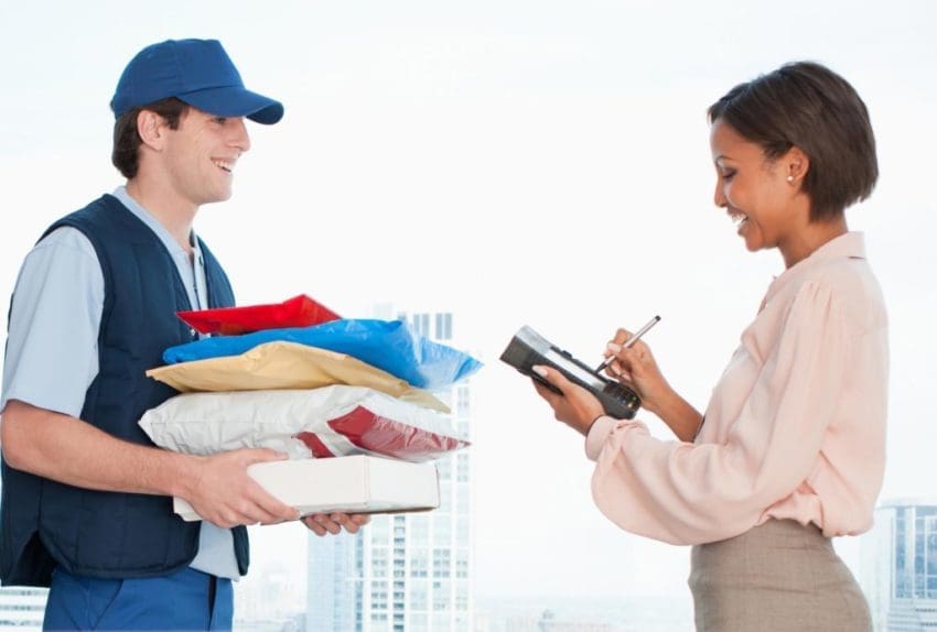 Businesswoman signing for package in office