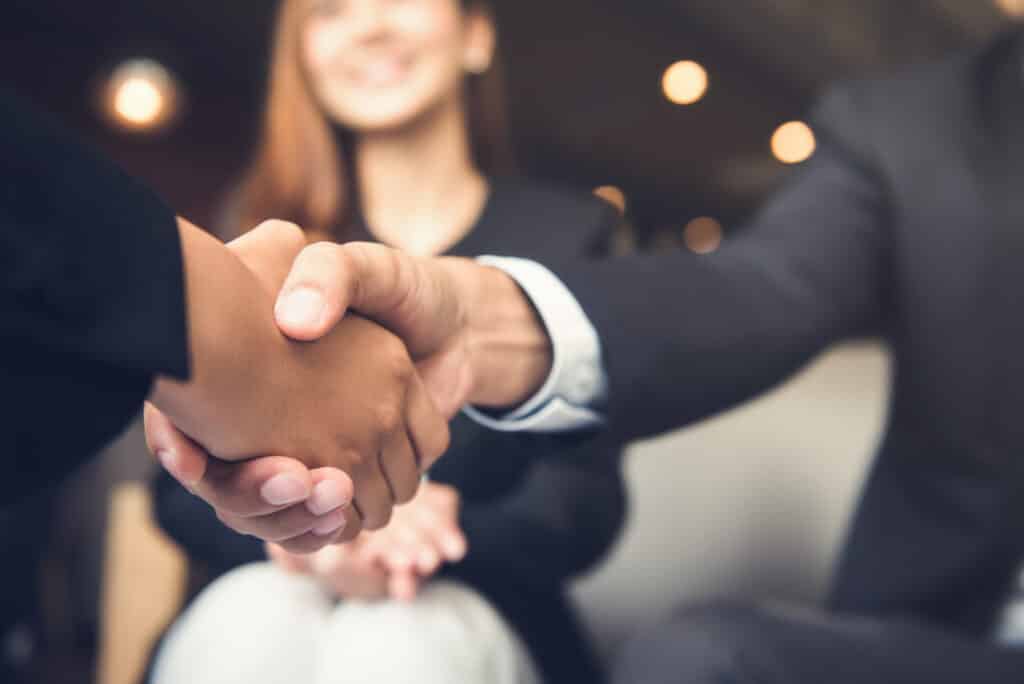 Businessmen,Making,Handshake,With,His,Partner,In,Cafe,-,Business