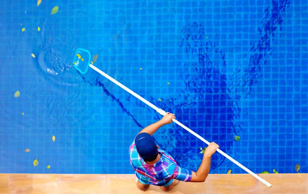 Young,Adult,Man,,Personnel,Cleaning,The,Pool,From,Leaves